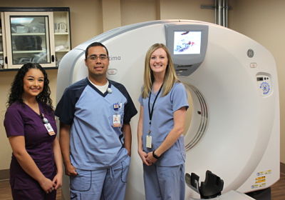 Picture of Ward Memorial Hospital Radiology Staff (two females and one male) standing in front of the new GE state-of-the-art CT, Digital Radiography machine.