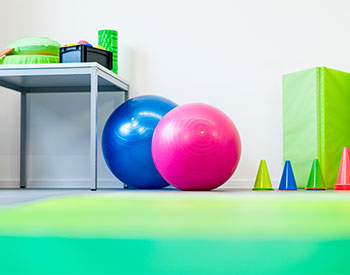 Physical Therapy room with therapy equipment. There is two exercise balls and four cones